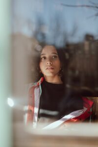 Young woman looking out a window thoughtfully